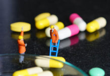 Miniature people - The worker at work with medicine pills